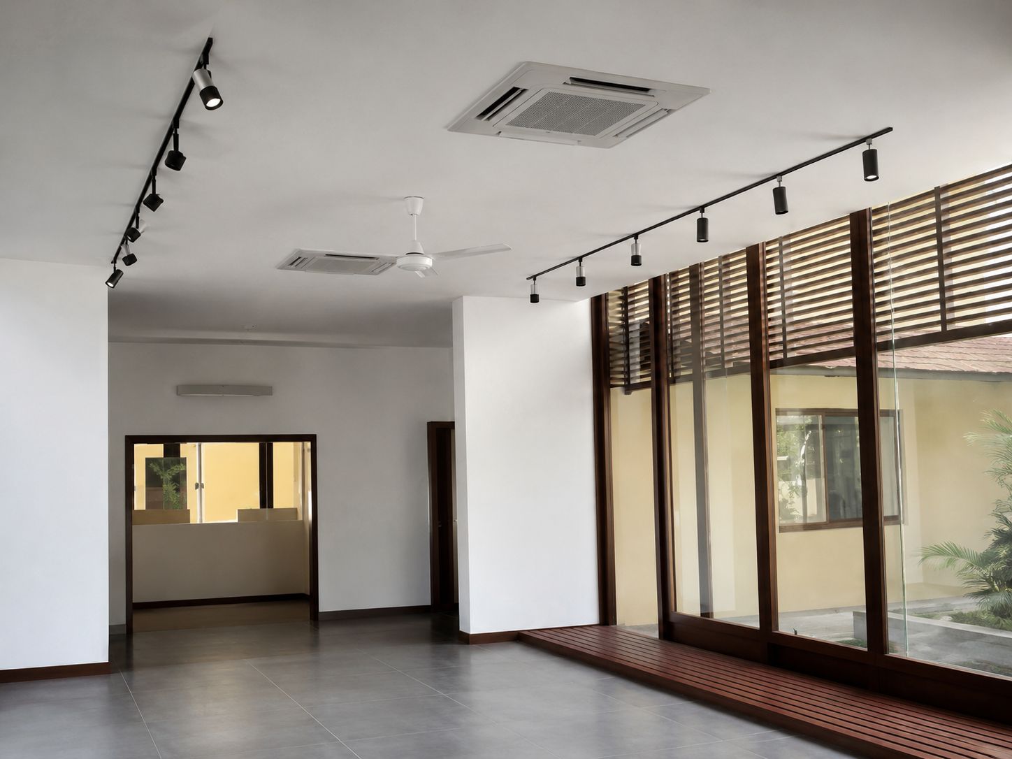 Banking hall interior with black track lighting running across a white ceiling, ceiling cassette units and a glazed timber facade