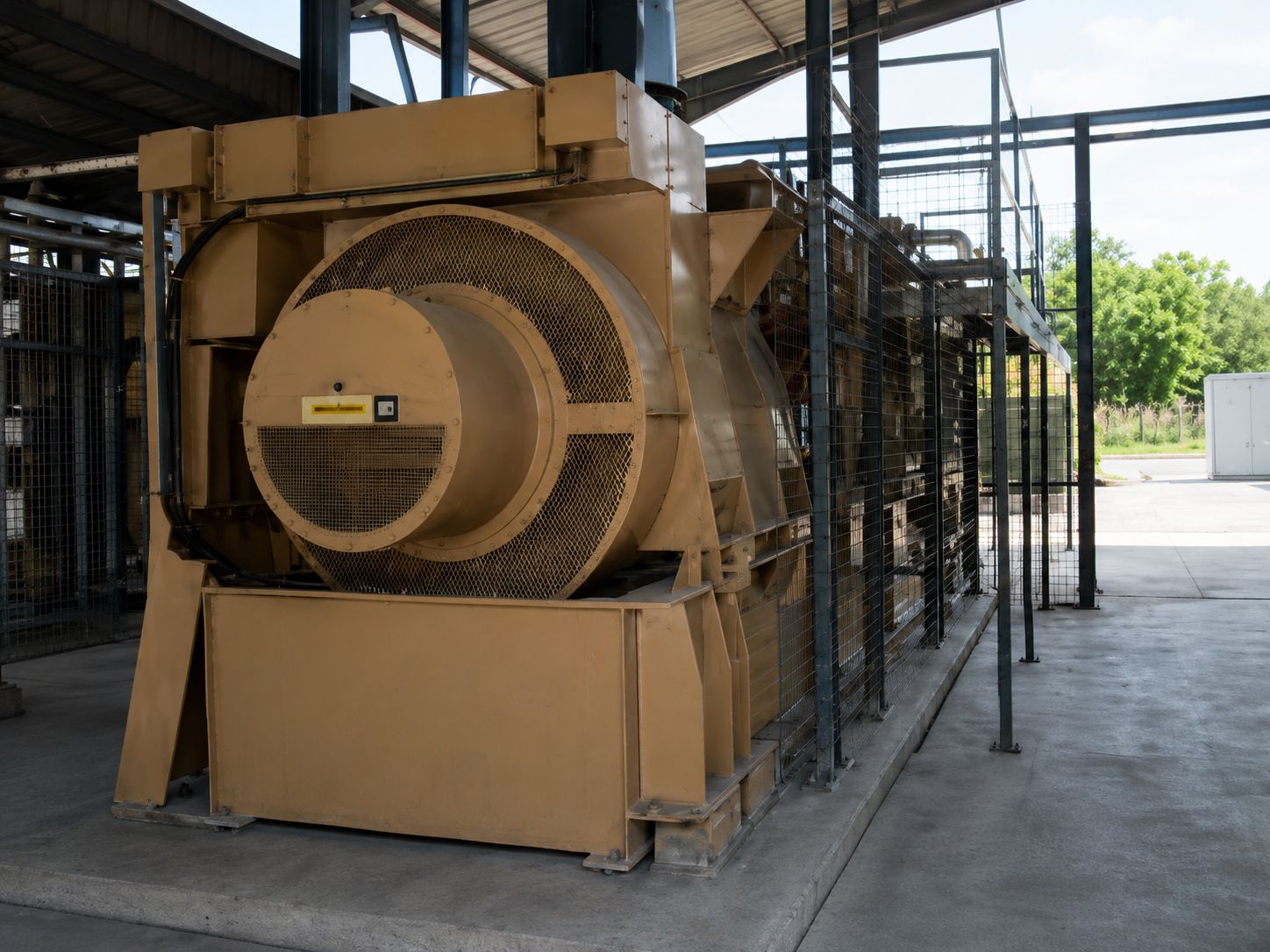 Large enclosed plant equipment with a mesh guard and access barriers under a canopy